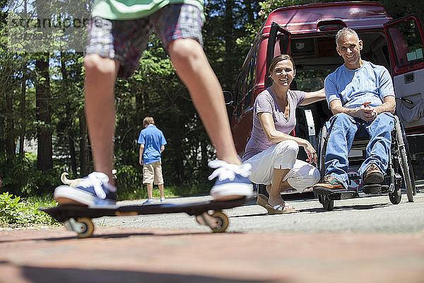 Ehepaar beobachtet seinen Sohn auf dem Skateboard
