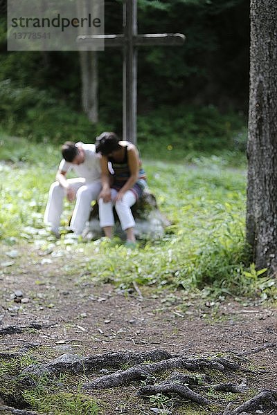 Ein Ehepaar betet gemeinsam im Freien.