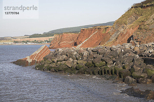 Felsenpanzer am Fuß bröckelnder roter Sandsteinklippen zur Eindämmung der Küstenerosion  Watchet  Somerset  England