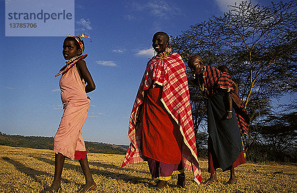 Maasai-Frauen  eine trägt ein Baby auf dem Rücken und ein Kind Narotian  Masai Mara  Kenia