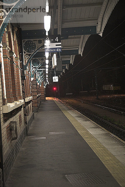 Verlassener Bahnsteig eines Bahnhofs bei Nacht