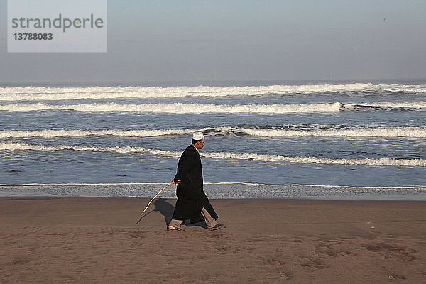 Marokkanischer Mann bei einem Spaziergang am Strand von Azemmour