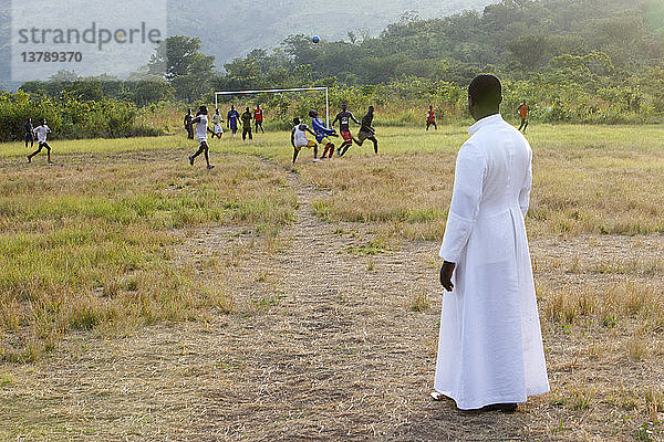 Katholischer Priester sieht sich ein Fußballspiel an