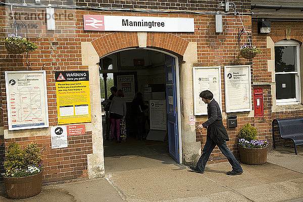 Mann betritt den Eingang des Bahnhofs Manningtree  Essex  England