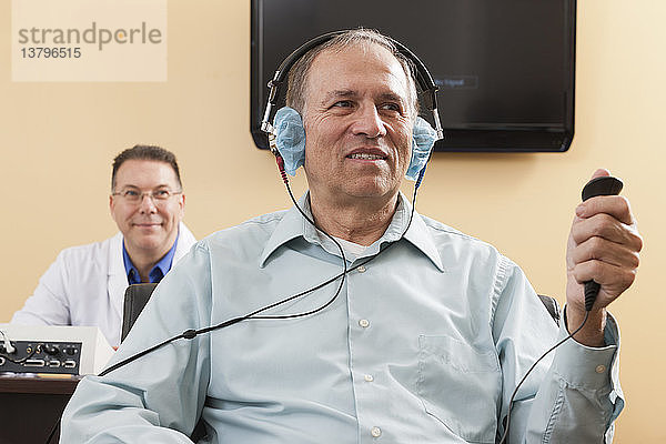 Patient benutzt Antworttaste während der audiometrischen Untersuchung