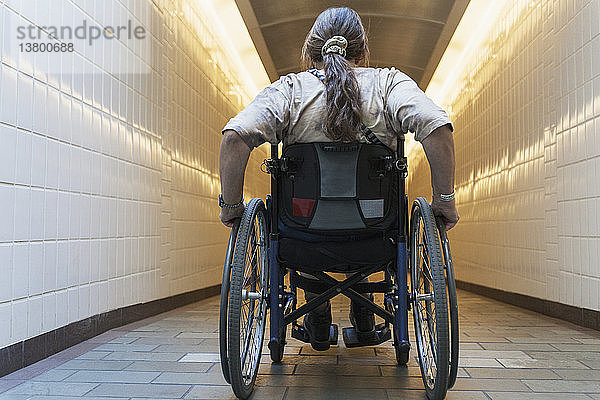 Frau mit Querschnittslähmung im Rollstuhl beim Betreten einer U-Bahn-Station  Boston  Massachusetts  USA