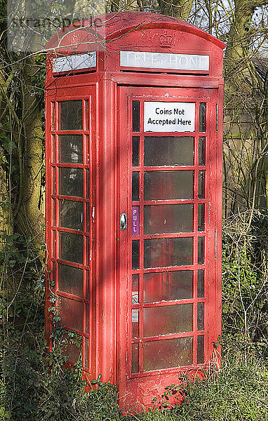 Schild Coins Not Accepted Here (Münzen werden hier nicht angenommen) auf einer roten Telefonzelle  Suffolk  England