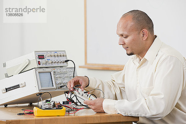 Ingenieurstudent bei der Vorbereitung eines elektrischen Experiments auf einem Protoboard