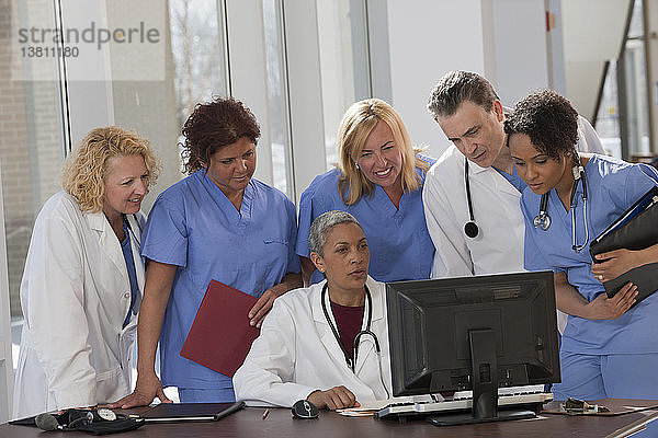 Ärzte und Krankenschwestern beraten sich an einem Computer im Krankenhaus