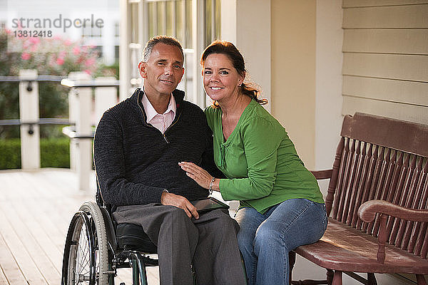 Porträt eines glücklichen Paares mit dem Mann im Rollstuhl
