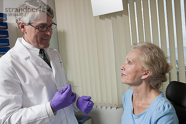 Augenarzt im Gespräch mit einem Patienten vor einer Botox-Behandlung