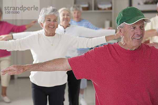 Senioren bei Übungen zur Stärkung der Arme in einem Fitnessstudio
