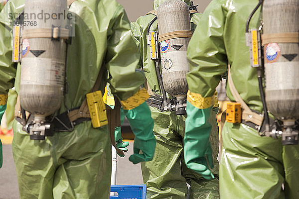 Rückansicht von HazMat-Feuerwehrleuten mit Atemluftflaschen