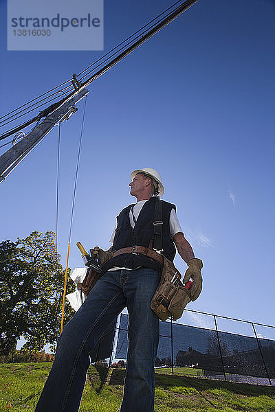 Ingenieur bei der Vorbereitung der Installation von Geräten an einem Strommast