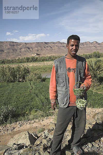 Freundlich lächelnder junger Mann verkauft frische Datteln am Ksar von Tamnougalt  Draa-Tal  Marokko
