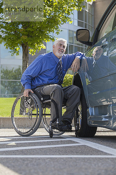Mann mit Muskeldystrophie und Diabetes in einem Rollstuhl neben einem behindertengerechten Lieferwagen
