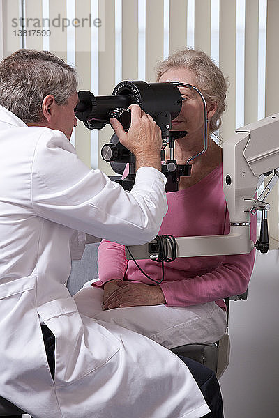 Augenarzt untersucht die Augen einer Frau mit einem Keratometer