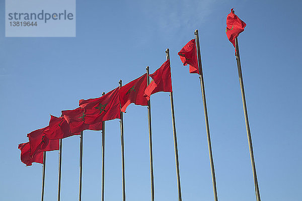 Nationalflaggen mit roten Sternen an Fahnenmasten unter blauem Himmel  Essaouira  Marokko