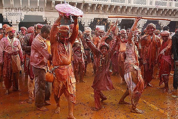 Dorfbewohner von Barsana feiern Holi in Nandgaon und verhöhnen Dorfbewohner von Nandgaon  die sie mit farbigen Flüssigkeiten übergießen.