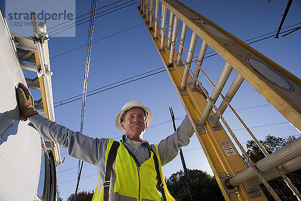Ingenieur hält eine Leiter am Standort einer Stromleitung
