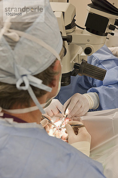 Chirurgische Technikerin schneidet in Zusammenarbeit mit dem Chirurgen Nahtmaterial