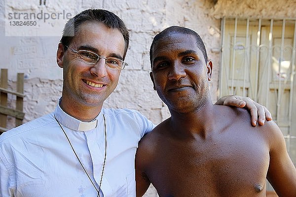 Der französische Priester Etienne Kern mit einem Gemeindemitglied in der Favela Alagados.