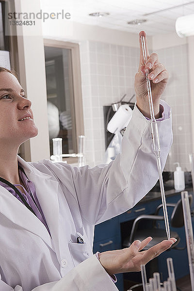 Wissenschaftler hält eine Pipette im Labor einer Wasseraufbereitungsanlage