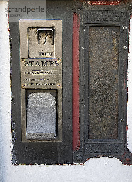 Alter ausgedienter Briefmarkenautomat und Briefkasten