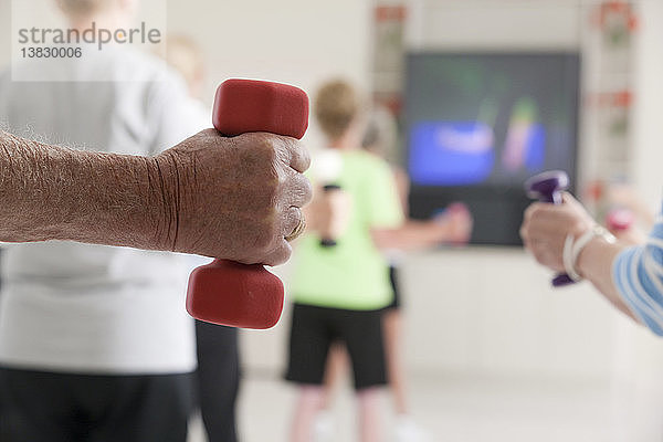 Senioren beim Training mit Hanteln in einem Fitnessstudio