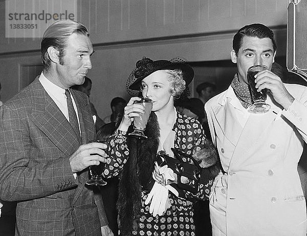 Hollywood  Kalifornien: ca. 1936 Die Filmstars Randolph Scott  Virginia Bruce und Cary Grant genießen Getränke bei einer Veranstaltung in Hollywood.