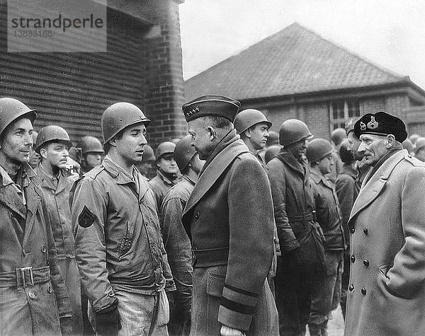 England: 11. März 1944 Der Befehlshaber der alliierten Invasionstruppen  General Dwight Eisenhower  hält an  um ein paar Worte mit Männern einer Panzerdivision zu wechseln. Rechts steht der britische General Bernard Montgomery mit seiner Baskenmütze.
