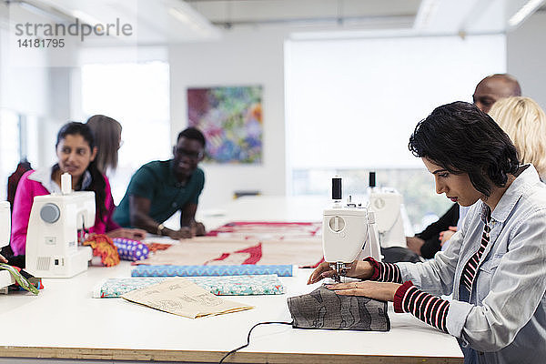 Modedesignstudenten bei der Arbeit an den Nähmaschinen im Atelier