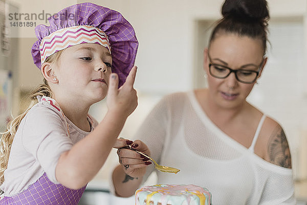 Mutter und Tochter dekorieren Kuchen