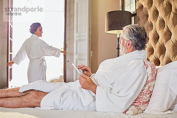 Älteres Paar in Bademänteln entspannt sich in einem Hotelzimmer