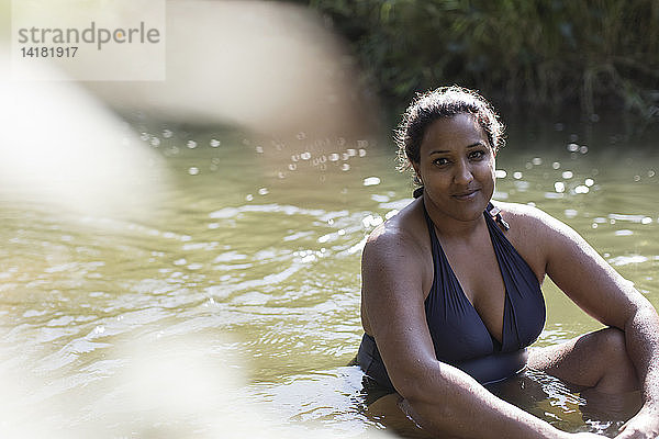 Porträt lächelnde Frau entspannt in sonnigen Fluss