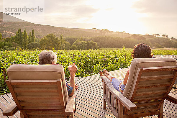 Ein Paar entspannt sich und trinkt Wein auf der sonnigen  idyllischen Terrasse eines Ferienortes