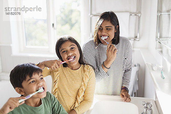 Porträt einer glücklichen Familie beim Zähneputzen im Badezimmer