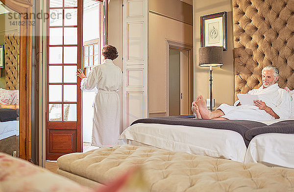 Paar in Bademänteln entspannt in einem Hotelzimmer