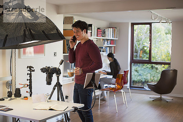 Männlicher Fotograf bei der Arbeit im Studio  in der Kaffeepause