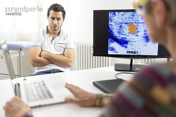 Ein Mann konsultiert eine Ärztin für eine Prostata-Ultraschalluntersuchung.