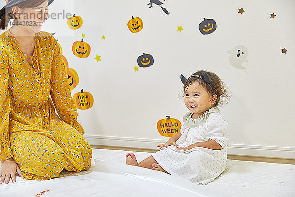 Japanisches Kind und Mutter bereiten sich auf Halloween vor