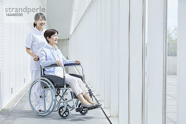 Japanische Pflegerin hilft älteren Patienten