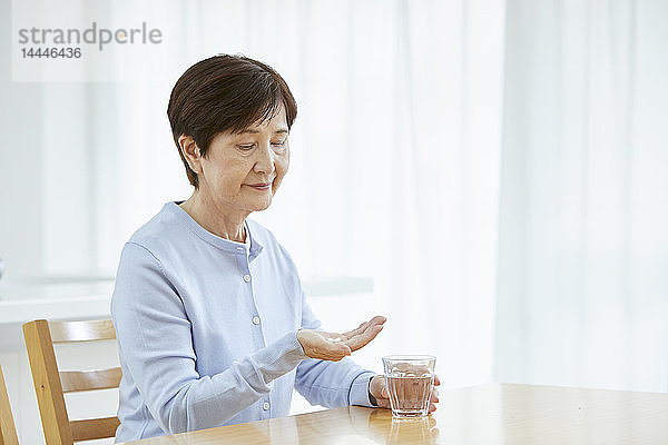 Japanische Seniorin nimmt Pillen