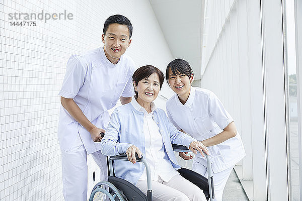 Japanische Pfleger helfen älteren Patienten