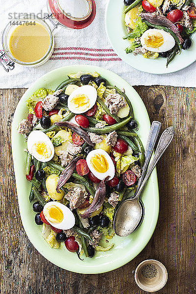 Salat nicoise mit Römersalat  Kirschtomaten  Thunfisch  grünen Bohnen  schwarzen Oliven  Sardellen und hartgekochten Eiern