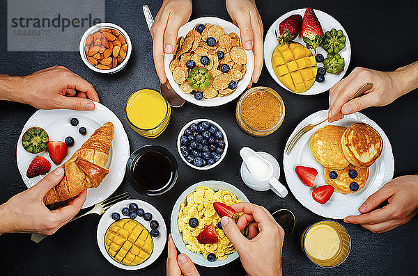 Gedeckter Frühstückstisch mit Flocken  Saft  Croissants  Pfannkuchen und frischen Beeren