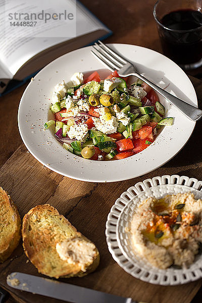 Griechischer Salat mit Hummus und geröstetem Brot