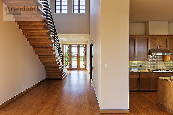 Geräumiger Flur mit einer Treppe und einer modernen Küche