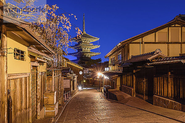 Traditionelle Häuser an einer engen Straße mit einer Pagode in der Ferne  Higashiyama bei Nacht  Kyoto  Japan.