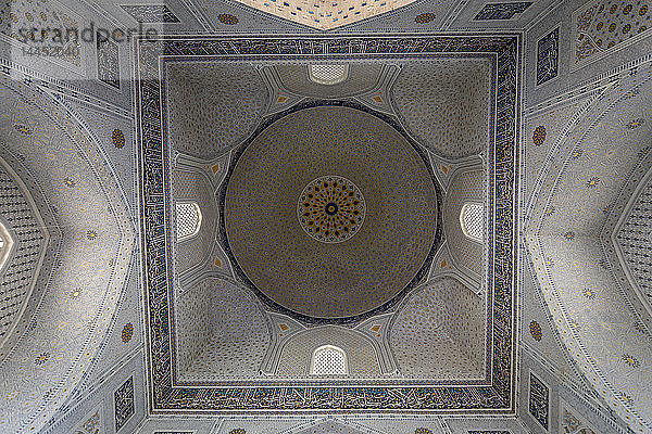 Niedrigwinkelansicht der Decke und der mit Mosaikfliesen verzierten Kuppel in einer Madrasa in Samarkand.